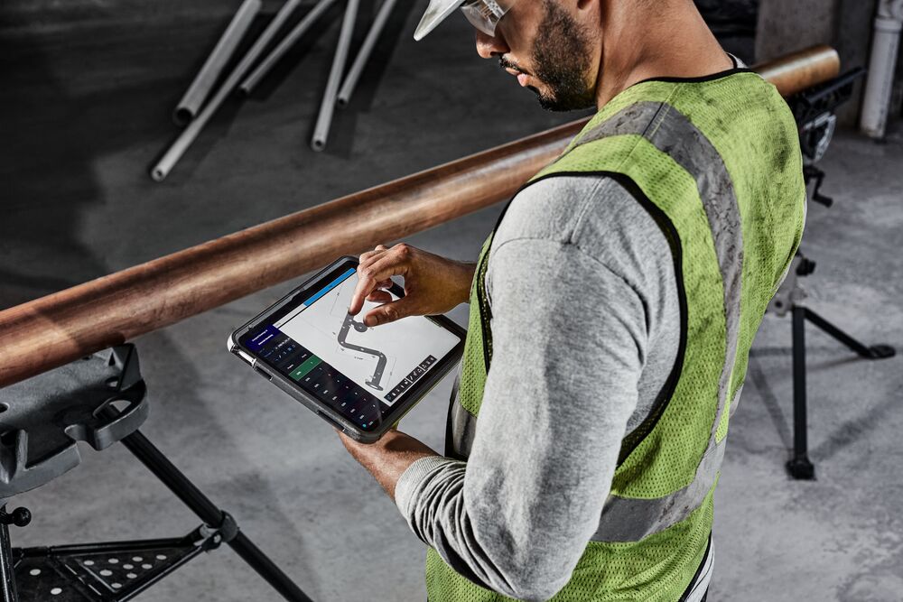 Close up of a mechanical contractor using MSUITE on an iPad at a jobsite