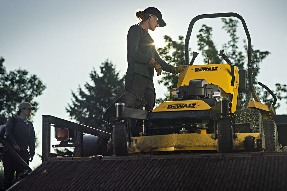 48 inch Kawasaki Gas Hydrostatic Commercial Hydro Walk Mower being used by person to mow grass outdoors.