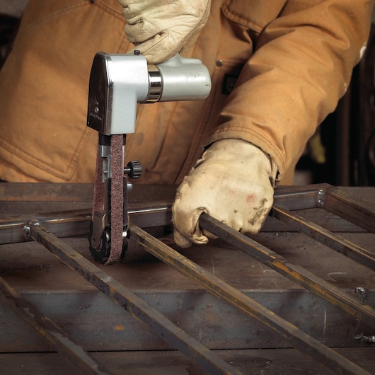 3 quarters Inch by 18 Inch Medium Non Woven File Belt being used with power tool on metal.